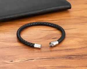 Dettaglio del bracciale in pelle intrecciata nera con chiusura magnetica in argento