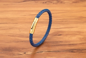 Nahaufnahme eines blauen Lederarmbands mit einem polierten goldfarbenen Metallverschluss