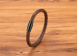 Dettaglio del cordino in pelle intrecciata marrone con chiusura magnetica in acciaio nero opaco