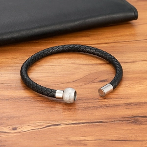 Bracciale intrecciato in pelle nera da uomo con chiusura magnetica argento su legno