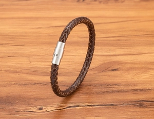Dettaglio del bracciale in pelle marrone scuro intrecciata a mano con chiusura magnetica