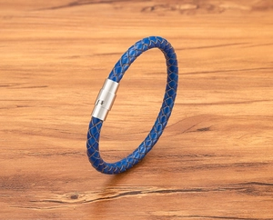 Dettaglio di bracciale in pelle intrecciata blu con chiusura magnetica in argento
