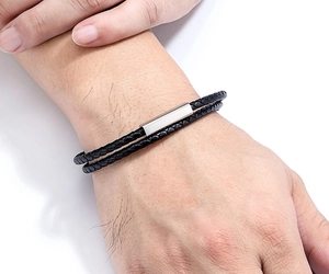 Close-up of double-layer black leather woven bracelet with silver magnetic metal clasp