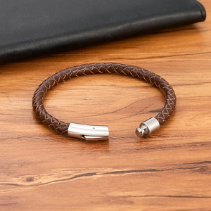 Geflochtenes braunes Lederarmband für Herren mit poliertem Edelstahlverschluss auf Holz