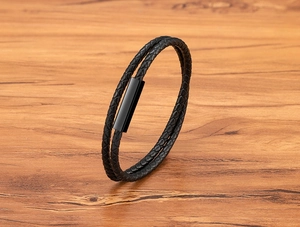 Detail of double-layer black braided leather bracelet with glossy magnetic metal clasp