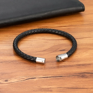 Bracciale in pelle nera intrecciata con chiusura magnetica in acciaio inox su legno
