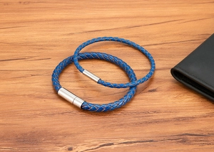 Gros plan de bracelets en cuir tressé bleu avec fermoirs magnétiques en acier