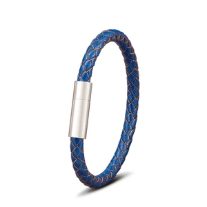 Détail d'un bracelet en cuir tressé bleu avec un fermoir magnétique cylindrique argenté