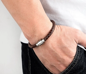 Gros plan d'un bracelet en cuir tressé marron foncé pour homme avec fermoir magnétique en argent