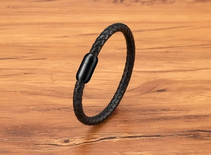 Détail du bracelet en cuir tressé noir avec un fermoir magnétique cylindrique noir mat