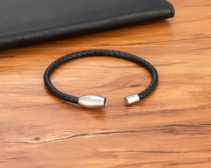 Macro shot of men's braided leather bracelet featuring a magnetic stainless steel clasp