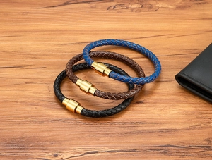 Détails de bracelets en cuir tressé bleu, marron et noir avec fermoirs magnétiques dorés