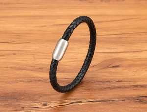 Détail du bracelet en cuir tressé noir avec fermoir magnétique en acier inoxydable brossé