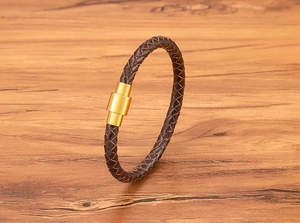 Détail du bracelet en cuir tressé marron foncé avec fermoir magnétique cylindrique doré