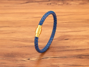 Détail macro du bracelet en cuir tressé bleu marine avec fermoir magnétique en acier doré