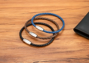 Detailed macro of woven leather bracelets in blue, brown, and black with magnetic buckles