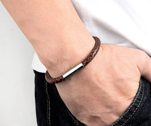 Close-up of a dark brown braided leather bracelet for men with silver cylinder magnetic clasp