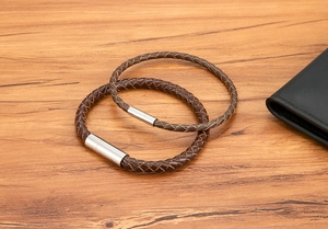 Detail view of brown braided leather bracelets with silver magnetic steel clasps