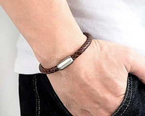 Detail eines dunkelbraun geflochtenen Lederarmbands mit mattem Edelstahl-Magnetverschluss