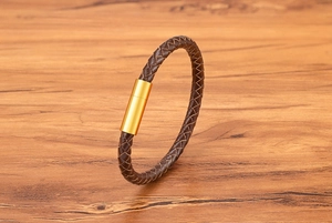 Macro shot of brown braided leather bracelet with magnetic gold stainless steel clasp