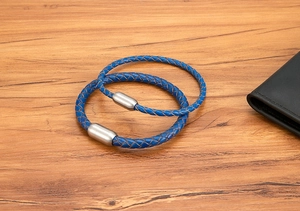 Nahaufnahme von blauen Lederarmbändern mit matten Magnetverschlüssen auf Holztisch