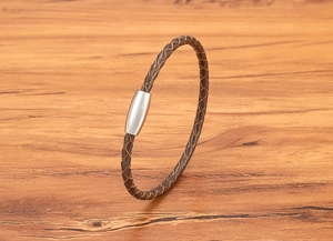 Close-up of brown braided leather cord with brushed stainless steel magnetic clasp