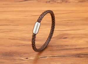 Detail von braunem geflochtenem Lederarmband mit mattem Magnetverschluss aus Edelstahl