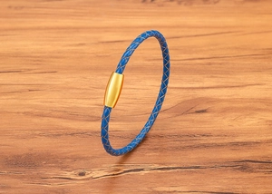 Detail of blue braided leather bracelet with a polished gold magnetic stainless steel clasp