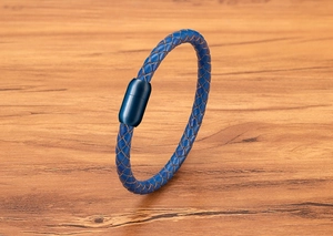 Nahaufnahme von blauem Lederarmband mit Magnetverschluss aus Stahl auf Holzhintergrund