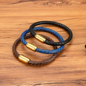 Dreiteiliges Lederarmband-Set mit mattgoldenen Magnetverschlüssen auf Holz