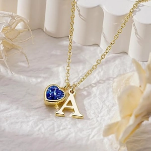 Minimalistische Goldhalskette mit blauem Herz-Edelstein und Buchstabe A auf Steinsockel