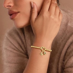 Bracelet à perles dorées avec fermoir cœur, breloque lettre M et pierre verte