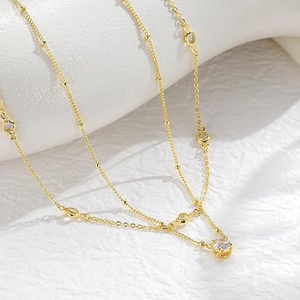 Double-layered titanium steel necklace with gold beads and sparkling crystal pendant