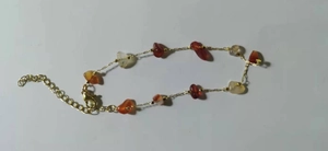 Detail of irregular natural red agate stone beads and gold chain bracelet with lobster clasp