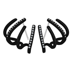 Detail of four-claw black ear cuffs with white zircon crystals on a plain background