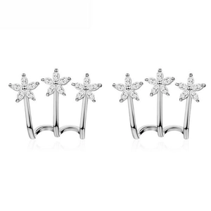 Detail of silver ear crawlers with sparkling zircon flowers showing fine jewelry craftsmanship