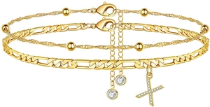 Detail von zweilagigen Goldketten mit einer Zirkonia-Perle und funkelndem Kreuzanhänger