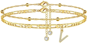 Nahaufnahme der goldenen Figaro-Kette mit Kristall-V-Anhänger und Perlen-Lagen-Design