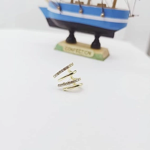 Detailed close-up of gold layered spiral ear cuff set with sparkling white zircons