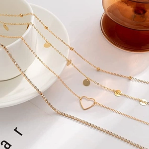 Four-piece stacked gold body chain set with heart pendant and sparkling sequins style