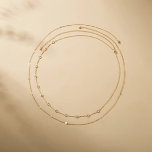 Detail of layered gold chains with round zircon stones and polished metal discs