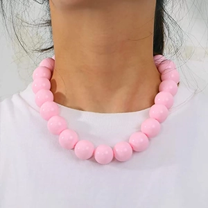Nahaufnahme einer leuchtend rosa Acrylperlenkette, getragen mit weißem T-Shirt