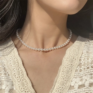 Collier de perles blanches classique sur modèle avec des perles rondes élégantes