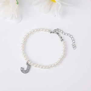 Detailed view of pearl bracelet with rhinestone letter J pendant and adjustable silver clasp