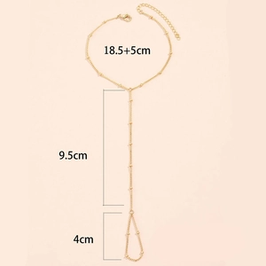 Detalle de la pulsera de anillo dorada con perlas blancas y cadena de extensión ajustable