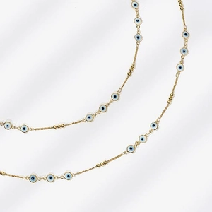 Détail de la chaîne de taille en or 14K avec breloques œil bleu et perles dorées