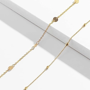Double-layered gold waist chain featuring flat round sequins and oval bead accents