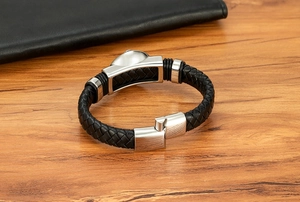 Dettaglio del bracciale uomo in pelle nera intrecciata con chiusura magnetica in acciaio