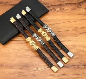 Detail of retro braided leather bracelets with metallic armor charms and magnetic clasps