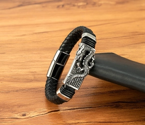 Detailansicht eines Herren-Lederarmbands in Schwarz mit geprägter Drachen-Metallplatte